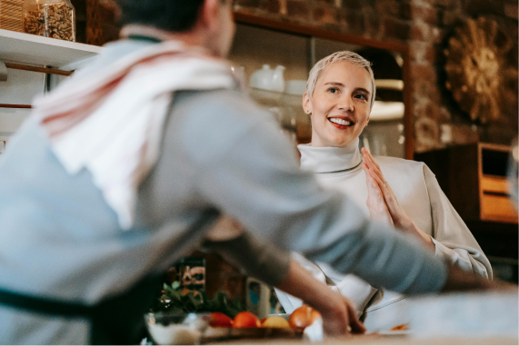 Workers in a restaurant kitchen smiling and cooking